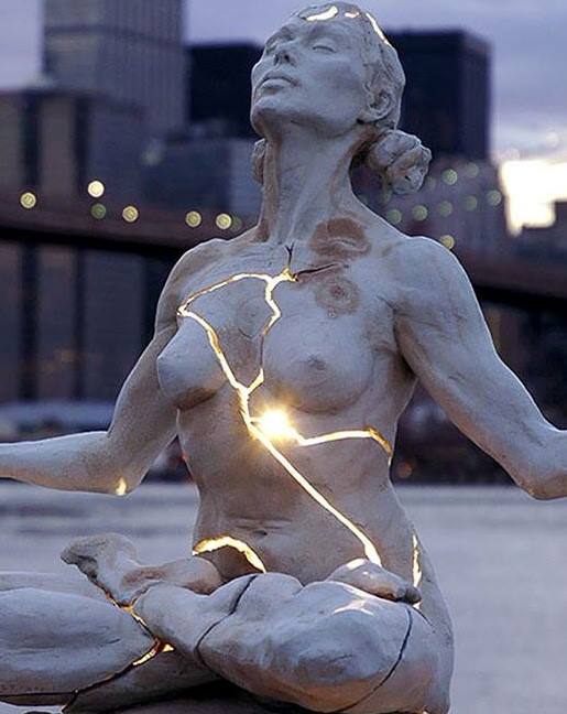 Statue of woman with golden cracks of light